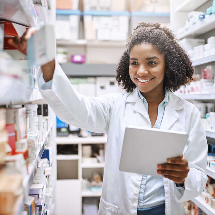 Young female pharmacy tech stock taking in a pharmacy